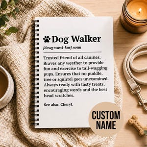 May include: A white spiral-bound notebook featuring a black printed definition of the term Dog Walker, including a paw print icon, phonetic spelling, and a descriptive paragraph about canine care, with a circular beige sticker labeled CUSTOM NAME.