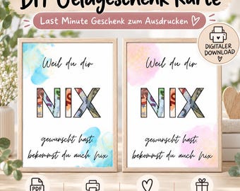 May include: Two framed rectangular prints featuring the German text 'Weil du dir NIX gewünscht hast, bekommst du auch nix' with the letters 'NIX' filled with euro banknote imagery. The left print has blue watercolour accents, and the right has pink.