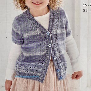May include: A child wearing a blue and white double knit cardigan with short sleeves and three blue buttons. The cardigan is paired with a pink tulle skirt. The text on the image reads "double knit" and "56-76 cm, 22-30 in."