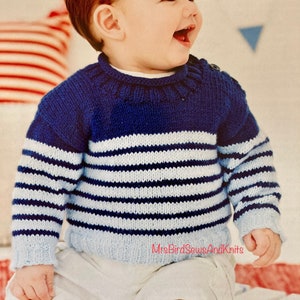 May include: A blue and white striped knitted jumper with a blue collar. The jumper is worn by a young child with red hair.