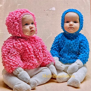 Puede incluir: Dos conjuntos de punto para bebé, uno rosa y otro azul, con gorros y botines a juego. Los conjuntos están hechos con un punto texturizado que se asemeja a pequeñas bolas.