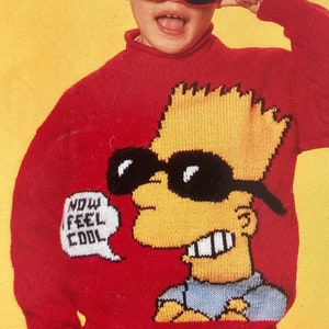 Può includere: Un maglione di lana rosso con un personaggio dei cartoni animati che indossa occhiali da sole e una nuvoletta che dice "NOW I FEEL COOL".