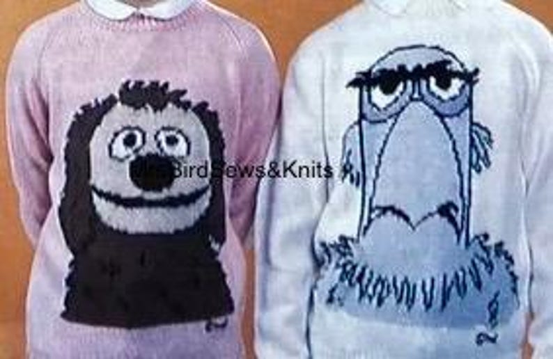 May include: Two knitted sweaters with cartoon animal designs. The pink sweater features a black dog with a brown nose and big eyes. The white sweater features a blue bird with a black beak and eyebrows.
