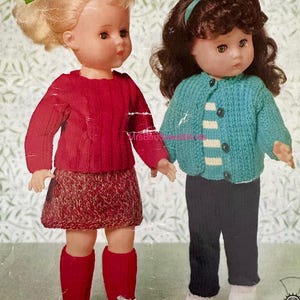 May include: Two vintage dolls in knitted outfits. One doll is in a red sweater, skirt, socks, and white shoes. The other doll wears a blue cardigan, black trousers, and white shoes. Both dolls have detailed facial features.