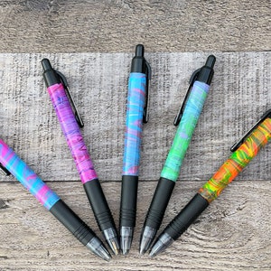 May include: Five black pens with colorful marbled designs. The pens have black ink and a clear plastic barrel. The marbled designs are in shades of pink, blue, green, and orange.