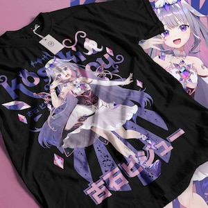 May include: Black t-shirt with a colourful anime-style illustration of a female character with purple hair and a white dress. The design includes Japanese text and geometric shapes in purple and pink. A tag is attached to the shirt.