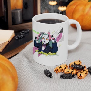 May include: White ceramic mug with a colorful illustration of a female character holding two guns. The character has green hair and is wearing a black jacket with a pink and white design. The text "Cyberpunk 2077" is printed on the mug.