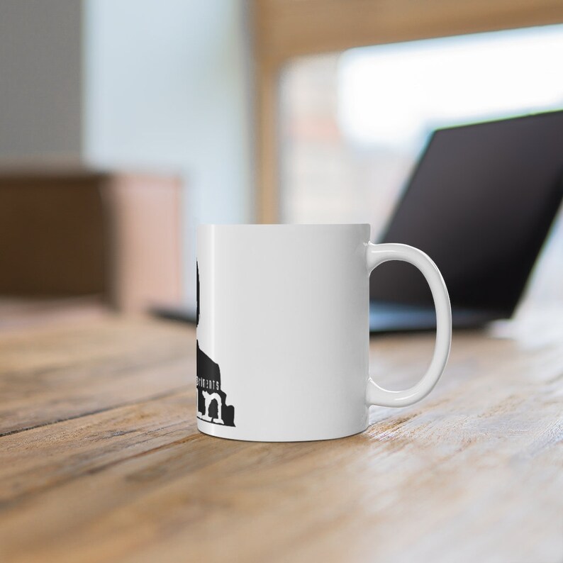 May include: White ceramic mug with a black silhouette of a person and the text "The moments that matter" printed on the side.