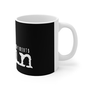 May include: White ceramic mug with a black design. The design features the text "Experiments in" and the word "Calm" in a stylized font.