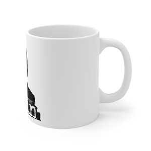 May include: White ceramic mug with a black silhouette of a person with the text "The Office" and "Assistant Regional Manager" printed on the mug.