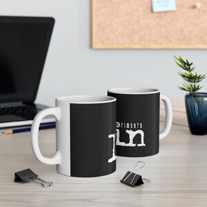 May include: Two white ceramic mugs with black handles. The mugs have a black background with white text that reads "Experiments in Film".