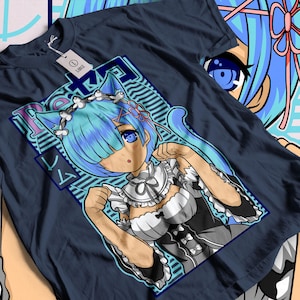 May include: A navy blue t-shirt featuring a cartoon illustration of a blue-haired anime character with cat ears. The character is wearing a white maid outfit against a blue and white patterned background. The text "Rem" is written in a stylized font above the character.
