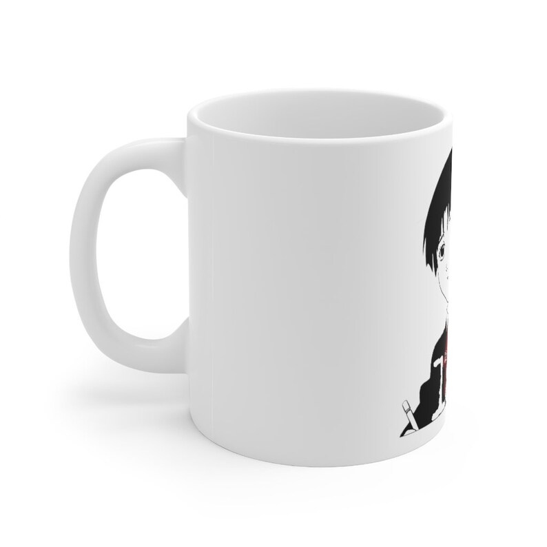 May include: White ceramic mug with a black and white illustration of an anime character with black hair and a red shirt holding a pencil.