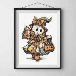 以下が含まれることがあります： パッチワークの衣装を着てカボチャのランタンを持っている、漫画の幽霊のキャラクターの額入りプリント。幽霊は、オレンジ、黄色、茶色のリボンとスカーフが付いた魔女の帽子をかぶっています。アートワークはテクスチャード加工が施されています。
