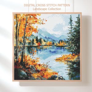 May include: A framed cross-stitch landscape depicting a tranquil lake scene with autumnal colours. The artwork features a palette of orange, yellow, blue, and green. The text "DIGITAL CROSS STITCH PATTERN Landscape Collection" is visible at the top.