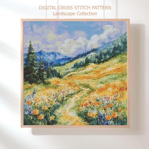 May include: Framed digital cross stitch pattern of a landscape scene. The artwork depicts a path winding through a field of yellow and orange flowers, leading towards a mountain range under a blue sky with fluffy clouds. The text "DIGITAL CROSS STITCH PATTERN Landscape Collection" is visible.