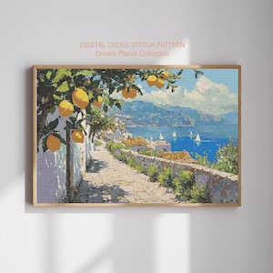 May include: A framed cross-stitch pattern depicting a coastal scene with a stone pathway, white buildings, and a blue sea dotted with sailboats. Lemon trees with yellow fruit hang over the path. The text "DIGITAL CROSS STITCH PATTERN Dream Places Collection" is at the top.