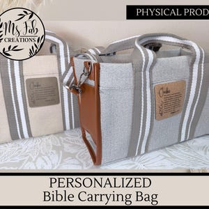 May include: Two canvas Bible carrying bags with vertical gray and white stripes. One bag has a brown leather accent and a silver clasp. The bags have handles and a small tag with text. The text "PHYSICAL PRODUCT" and "PERSONALIZED Bible Carrying Bag" are also visible.