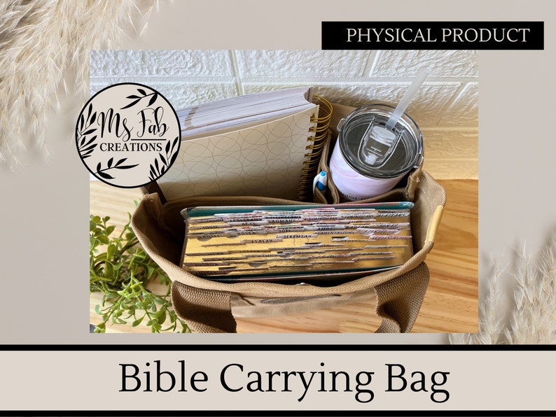 May include: A tan canvas tote bag with a zippered top, designed to carry a Bible, notebooks, and a tumbler. The bag is filled with a stack of books, a spiral notebook, and a tumbler with a straw. The bag has the text "Ms. Fab Creations" on a circular label.
