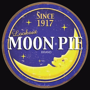 May include: A vintage-style logo for Lookout Moon Pie Brand, featuring a yellow crescent moon with a smiling face on a blue background with stars. The text "Lookout Moon Pie Brand" is in white with the words "Since 1917" above it.