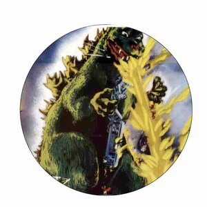 Peut inclure: Une illustration d'un monstre géant, Godzilla, détruisant une ville. Le monstre est vert et jaune, avec une grande gueule et des dents acérées. Il est entouré de flammes et de fumée.