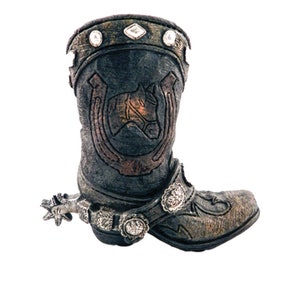 Puede incluir: Una bota vaquera marrón con un diseño de herradura y detalles plateados. La bota tiene una espuela y una hebilla decorativa.