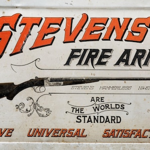 May include: Vintage sign for Stevens Fire Arms, featuring a rifle illustration. The sign has the text "STEVENS FIRE ARMS" in orange and black, with additional text: "ARE THE WORLDS STANDARD" and "GIVE UNIVERSAL SATISFACTION."