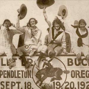 May include: A black and white photo of a group of women wearing cowboy hats and sitting on a wooden platform. The platform has a sign that reads "Let 'er Buck Pendleton Sept. 18. 19. 20. 1924 Oregon".