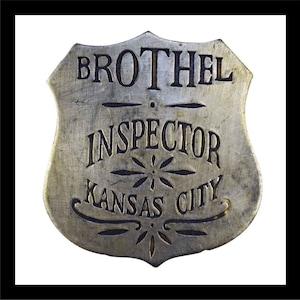 May include: A silver metal badge with the words "BROTHEL INSPECTOR KANSAS CITY" engraved on it.