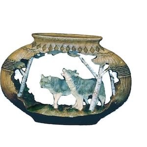 May include: An oval-shaped decorative vase with a carved design. The vase depicts two wolves in a forest setting, with one howling. The wolves are grey and white. The vase has a tan and brown colour scheme.