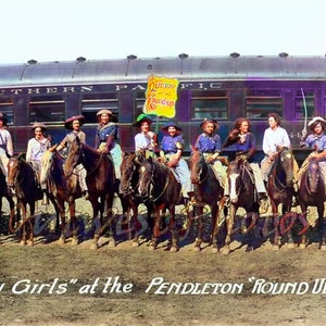 May include: A group of women dressed in Western attire, riding horses in front of a train car. The train car is purple and has the words "Southern Pacific" on the side. A sign above the women reads "Queen of the Round Up No. 1".