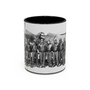 Può includere: Tazza in ceramica in bianco e nero con una fotografia d'epoca di un gruppo di aviatori davanti a un aereo da combattimento. La tazza ha un interno nero e un esterno bianco con l'immagine avvolta sulla superficie.