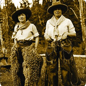 Puede incluir: Fotografía en tonos sepia de dos personas con atuendo de vaquero. Llevan sombreros de ala ancha, camisas claras y chaparreras. Las chaparreras de una persona son peludas, las de la otra de cuero con tachuelas y flecos. El fondo muestra un bosque.