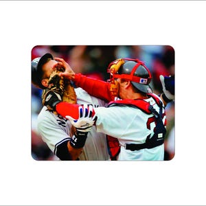 May include: A baseball catcher in a red and white uniform with a red helmet and a white face mask is blocking a batter with a white uniform and a black baseball cap. The catcher is wearing a chest protector and leg guards.