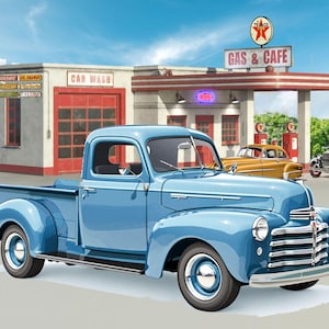 May include: A light blue vintage pickup truck is parked in front of a retro gas station and cafe. The gas station has a red and white color scheme with a Texaco sign. Other classic cars are also visible.