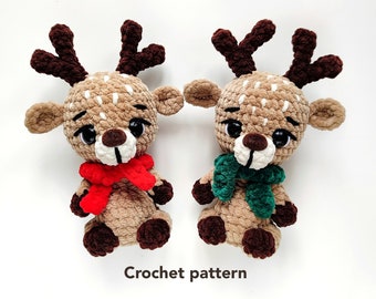 Puede incluir: Dos juguetes de reno tejidos a crochet con cuernos marrones, cuerpos marrones y blancos y una bufanda roja y verde. Patrón de crochet.
