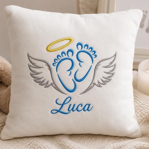 May include: A square white throw pillow featuring centered embroidery of two blue baby footprints with grey wings on either side and a yellow halo above. The name Luca is embroidered in blue script lettering below the footprints.