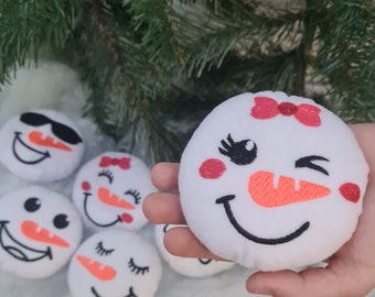 May include: Five white plush snowman ornaments with embroidered faces. One snowman has a red bow, one has sunglasses, and the others have different expressions.