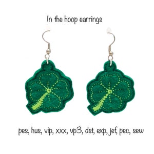 Può includere: Un paio di orecchini a forma di trifoglio a quattro foglie verdi con ganci d'argento. Gli orecchini sono in feltro e hanno un contorno cucito. "In the hoop earrings" è scritto sopra gli orecchini.
