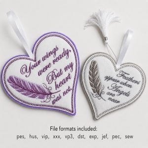 Op de afbeelding: Twee hartvormige viltornamenten met borduurwerk. Het linkerhart heeft een paarse veer en de tekst "Your wings were ready, But my heart was not." Het rechterhart heeft een grijze veer, een wit kwastje en "Feathers appear when Angels are near."