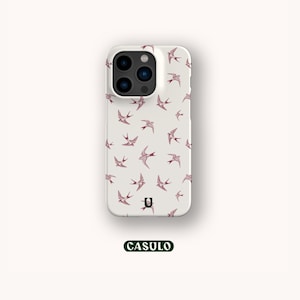 Könnte beinhalten: Weiße Handyhülle mit einem Muster aus rosa Vögeln. Die Hülle hat einen Kameraausschnitt und ein kleines "U"-Logo.