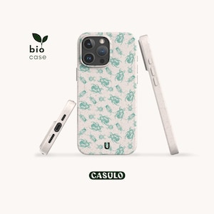 Könnte beinhalten: Hellweiße Handyhüllen mit einem türkisfarbenen Insektenmuster. Die Hüllen sind so angeordnet, dass das Design zur Geltung kommt, mit dem Logo "bio case" und dem Markennamen "CASULO". Handyhüllen für Smartphones.
