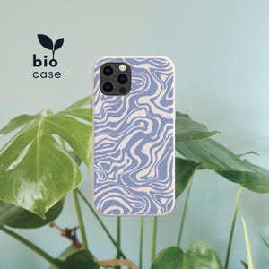 May include: A phone case with a light blue and off-white marbled wavy pattern. The case features a speckled texture and a camera cutout. The text bio case is printed in black with a small black leaf icon above the word bio in the upper left corner.