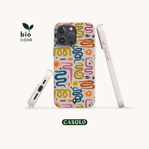 Può includere: Una cover per telefono bio case color bianco sporco maculato con un motivo ripetuto di serpenti, soli, stelle, occhi e fulmini colorati. Il design include elementi blu, gialli, rosa e arancioni. Il testo bio case e CASULO è visibile.
