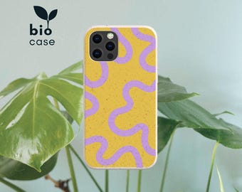 Peut inclure: Une coque de téléphone rectangulaire avec une base jaune moutarde présentant une texture mouchetée et un motif de lignes ondulées violet clair. La coque possède une découpe pour appareil photo. Le texte bio case est imprimé en noir.