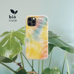 May include: A rectangular phone case with a tie-dye pattern in yellow, orange, and blue hues, featuring a speckled texture and a triple-lens camera cutout. The text bio case is printed in black with a small leaf icon above the word bio.