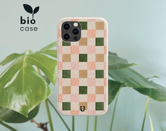 May include: A rectangular phone case featuring a checkered pattern of light pink, tan, and dark green squares with a speckled texture. The case has a camera cutout at the top left and a small U logo at the bottom. The text bio case is visible.