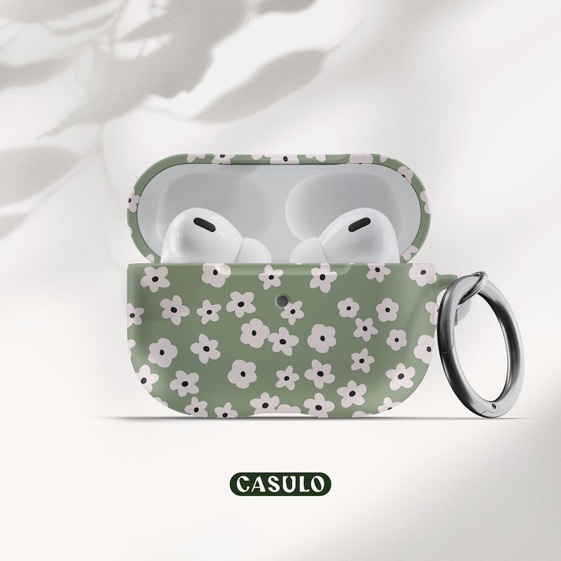 May include: A green and white floral patterned case for AirPods Pro with a matching keychain. The case has a small opening for the charging port and a small loop for the keychain.