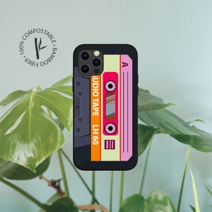 May include: A black phone case with a retro cassette tape design. The case has a light yellow background with a pink and orange cassette tape. The text "AUDIO TAPE LH 60" is printed on the cassette tape.