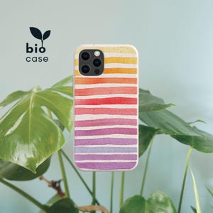 May include: A phone case with a speckled, off-white base featuring horizontal watercolor stripes in a gradient of yellow, orange, red, pink, and purple. The text "bio case" with a small leaf icon is positioned to the left of the phone case.